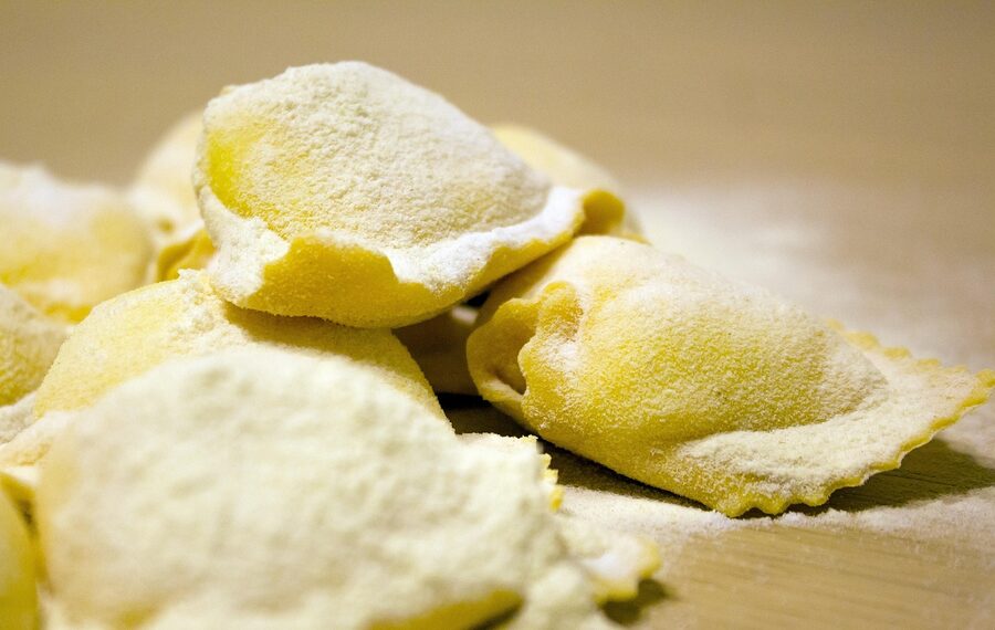 Stuffed Italian ravioli with ricotta filling on a wooden board