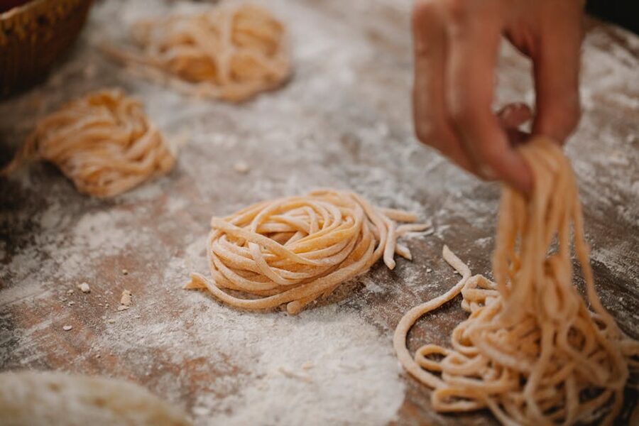 Raw pasta nests resting on a flour-dusted board after shaping