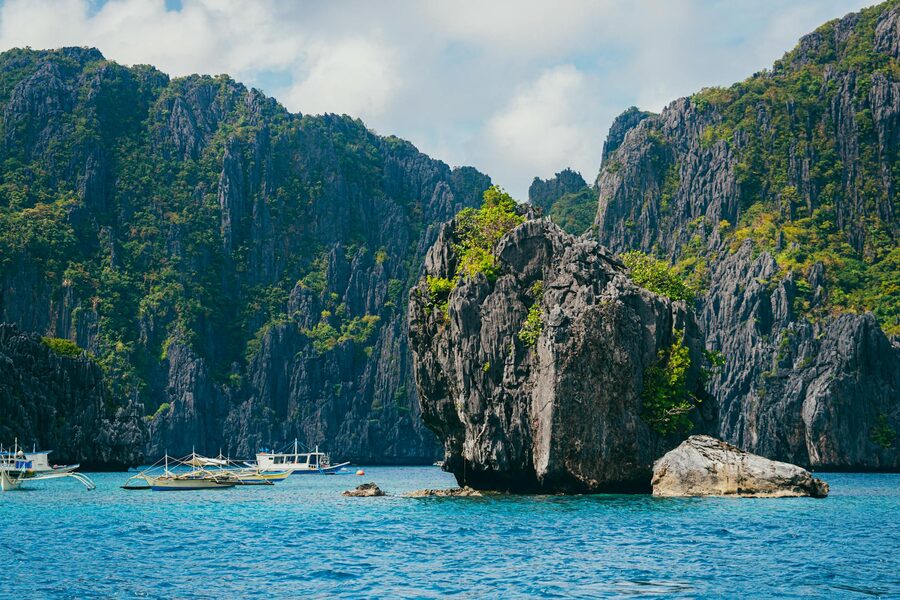 Tropical rock formations and boats in El Nido bay