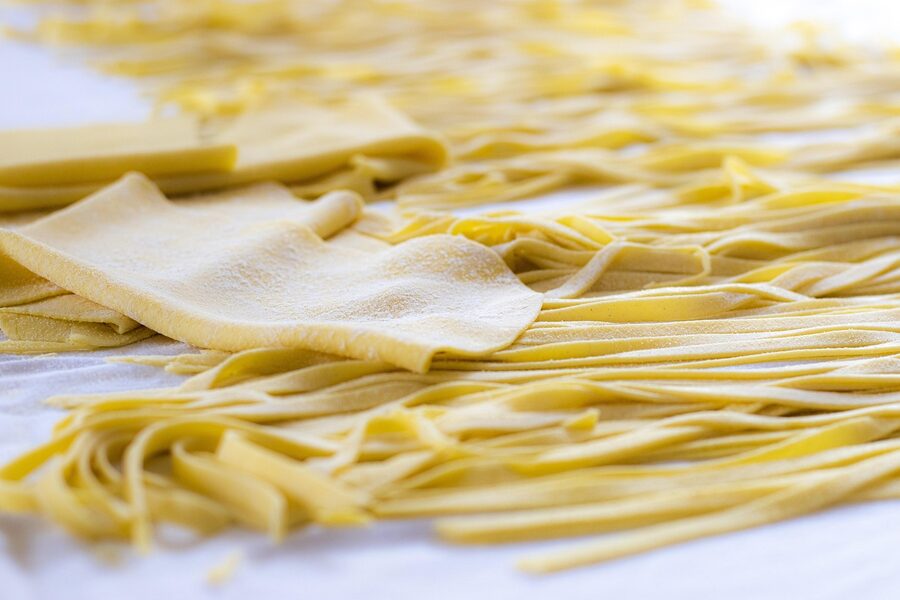 Fresh tagliatelle pasta nests on traditional wooden surface