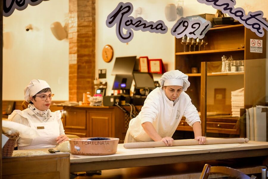 Italian chefs preparing pasta in a small kitchen