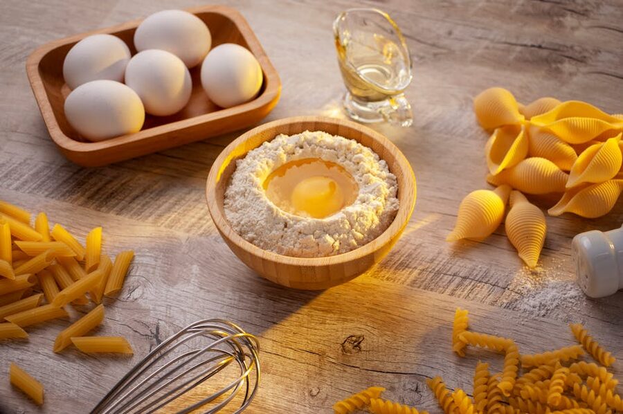 Fresh eggs and 00 flour on a wooden table for pasta dough