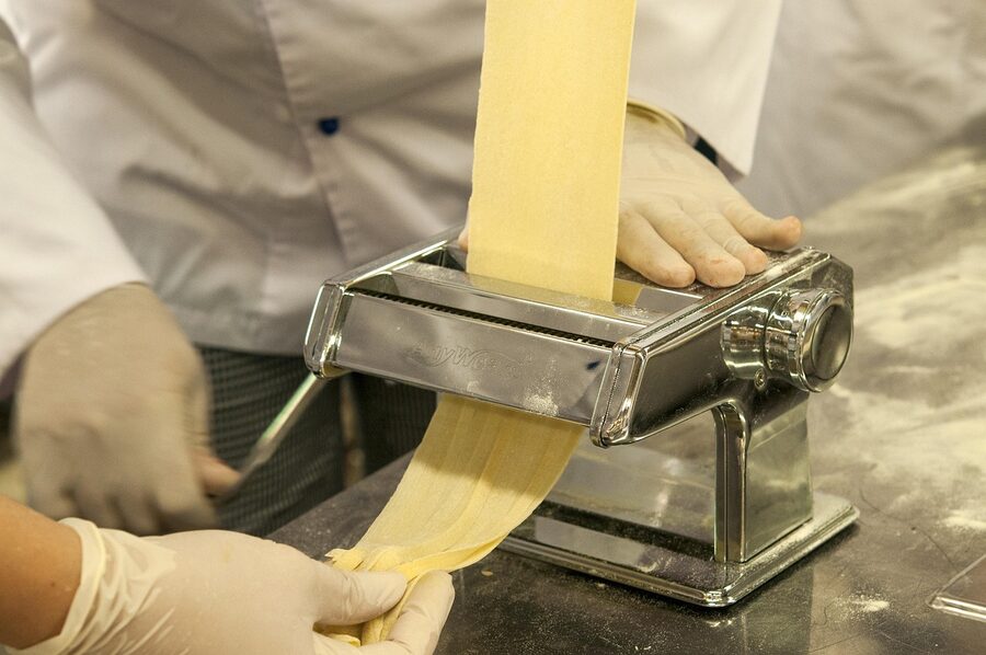 Italian chef working pasta dough on flour-dusted surface