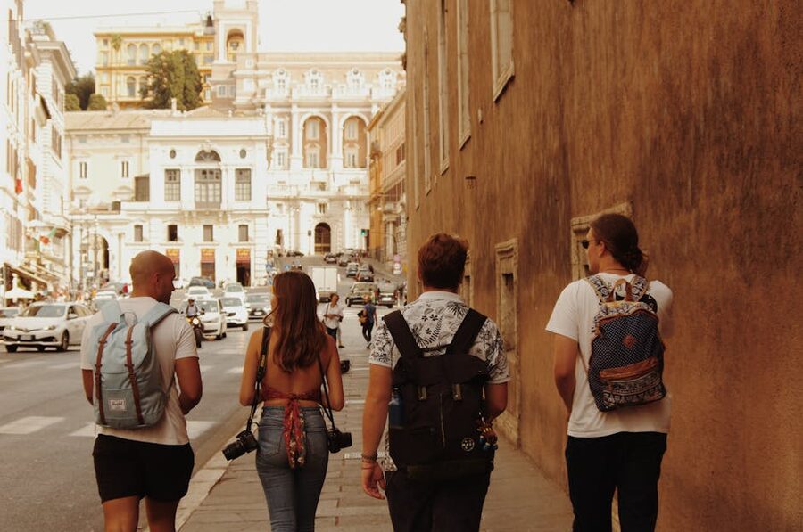 Tourists with backpacks walking Rome street