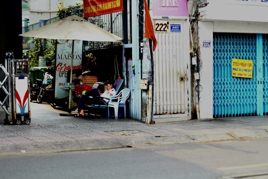 People relaxing near a street vendor in Saigon, Vietnam