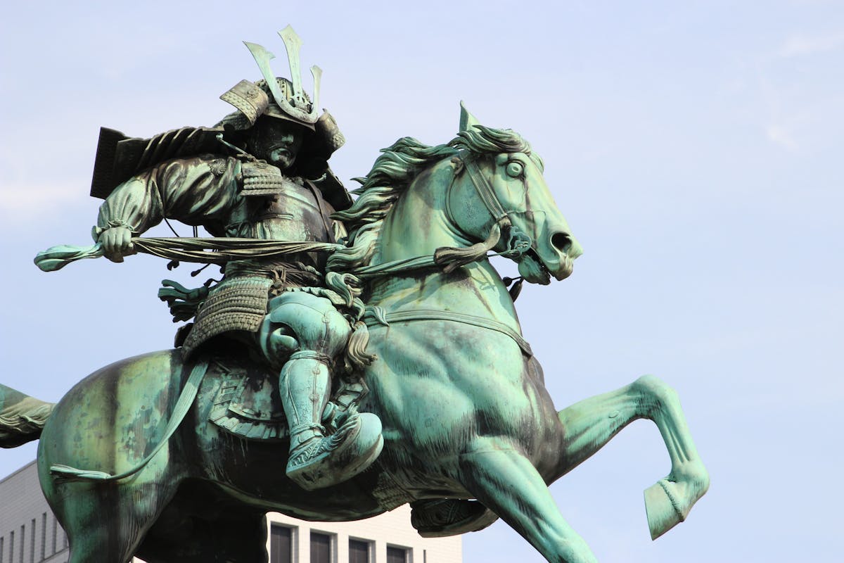 Detailed bronze statue of a samurai on horseback holding a weapon