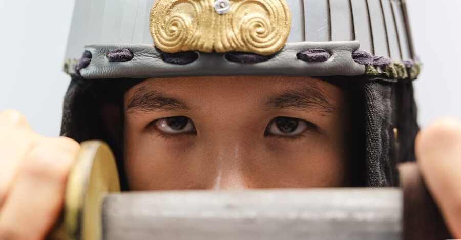 Close-up of samurai warrior with helmet holding sword