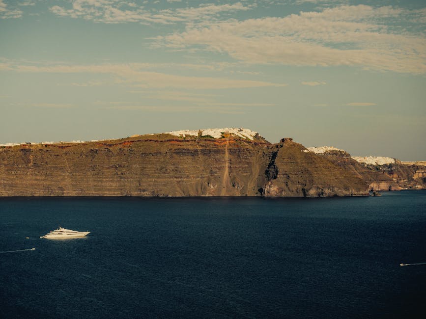 Santorini steep coastline cliffs from sea catamaran