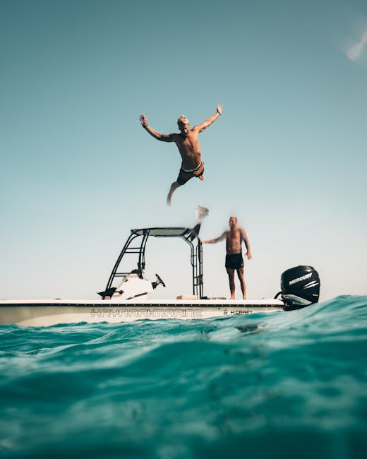 Two men jumping into sea from boat deck