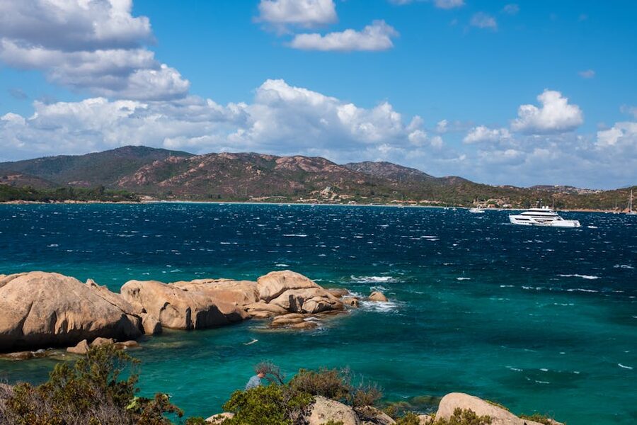 Sardinia coastline with yacht and clear blue waters