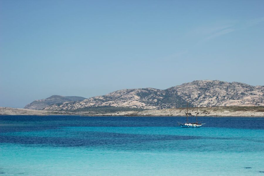 Yacht moored in clear water near rocky Sardinia coastline