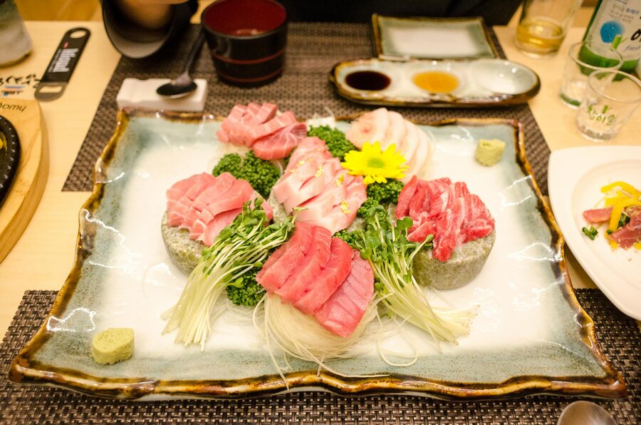 Sashimi selection with garnishes on a decorative plate