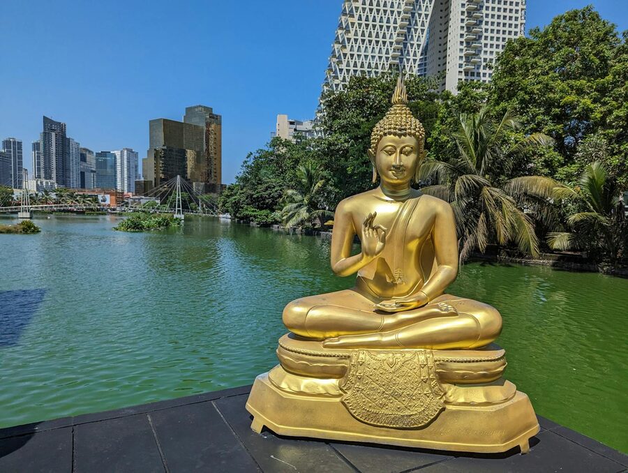 Golden Buddha statue beside the Beira Lake at Seema Malaka temple in Colombo