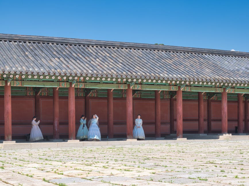 Two women wearing pastel hanboks posing at a Seoul palace