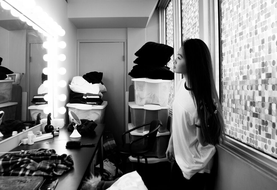Woman in a lit dressing room mirror for a styling session