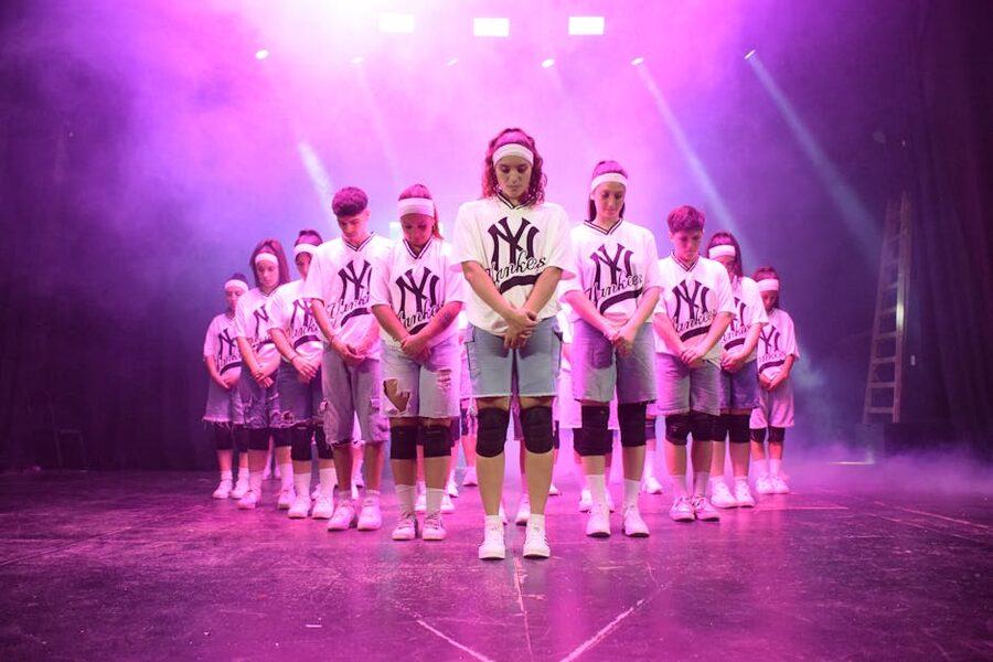 K-pop dance crew performing under stage lights