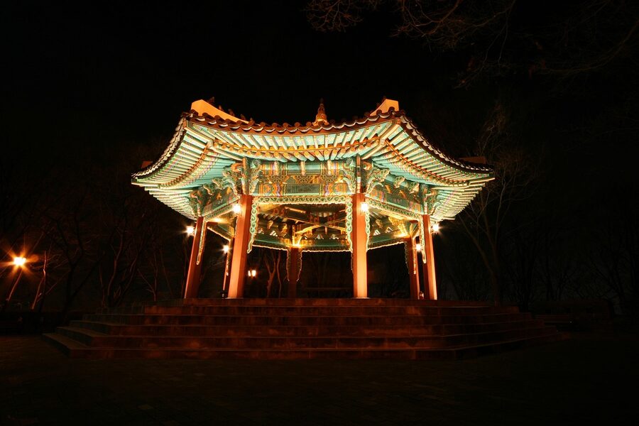 Hanok rooftops with Namsan Tower illuminated at night in Seoul