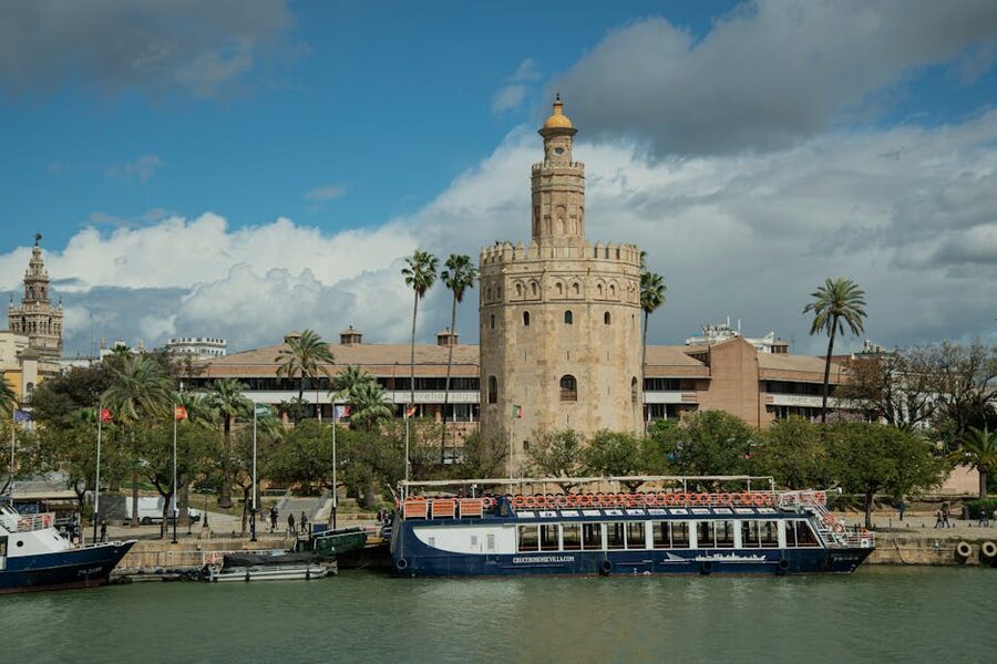 Cruise boat docked in front of Torre del Oro Seville
