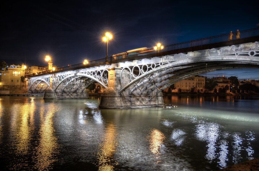 Triana bridge in Seville at night with city lights