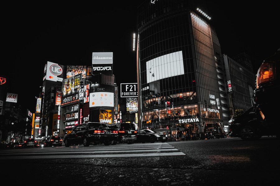 Busy Shibuya Crossing in Tokyo at night with illuminated billboards and pedestrians