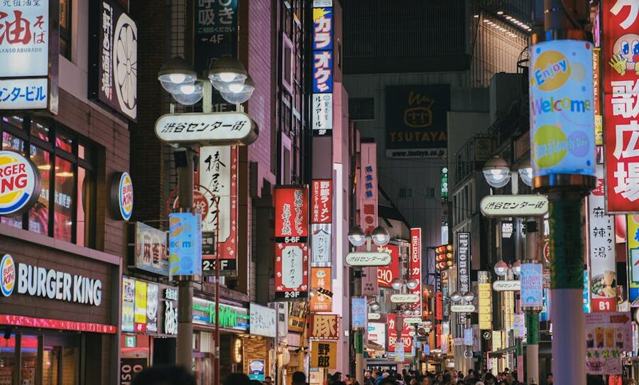 Neon-lit shops and streets in Shibuya district at night Tokyo