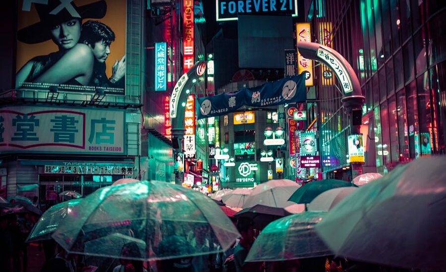 Shibuya streets at night in the rain with neon lights and umbrellas Tokyo