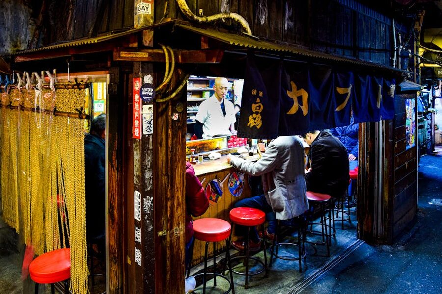 Diners eating at an Omoide Yokocho street cafe in Shinjuku at night