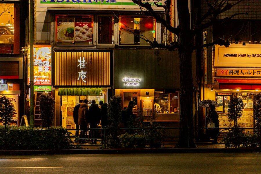 Night scene of ramen shops in Tokyo with patrons seated at the counter