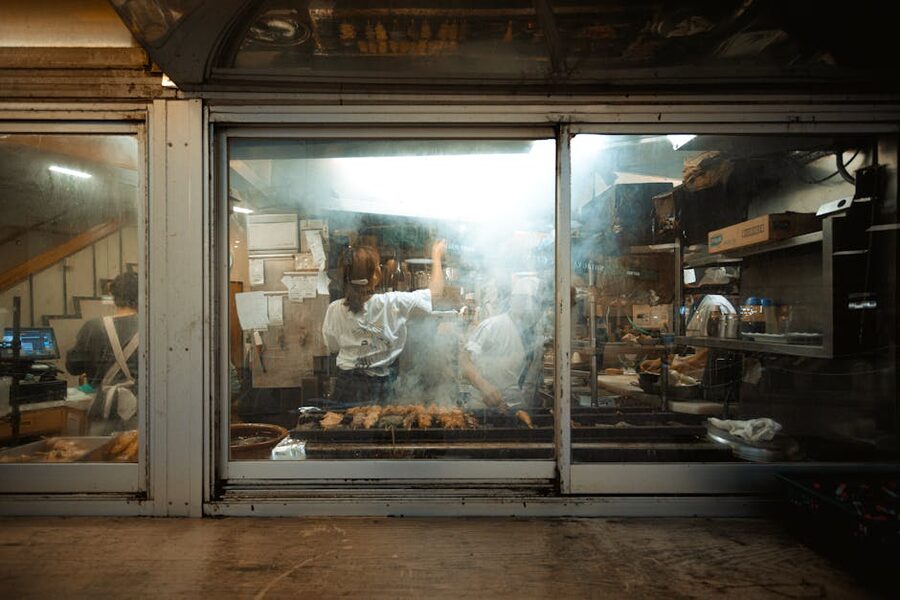 Chefs preparing food in a smokey kitchen at a Tokyo street food restaurant