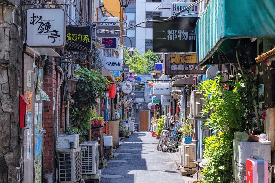 Colorful Shinjuku Golden Gai alleyway lined with tiny bars and hand-painted signs