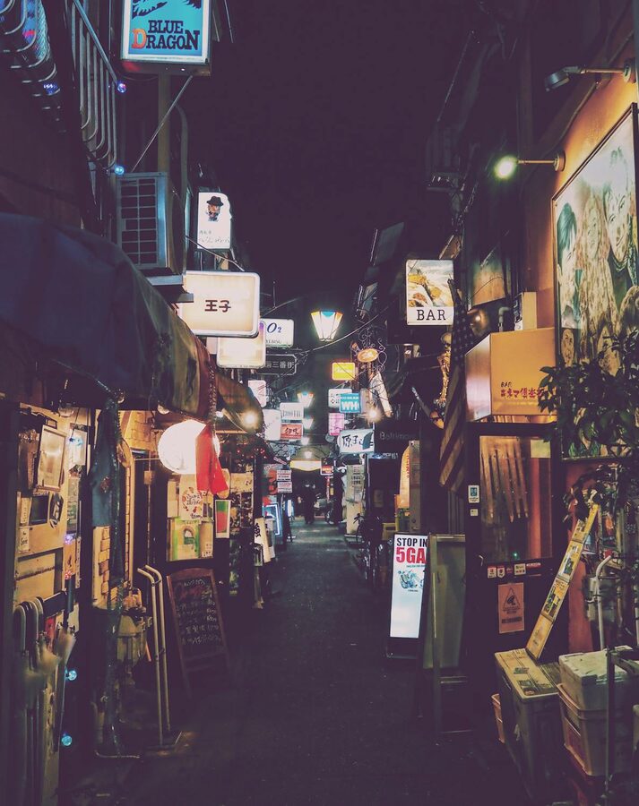 Narrow alley in Shinjuku lined with glowing signs and lanterns