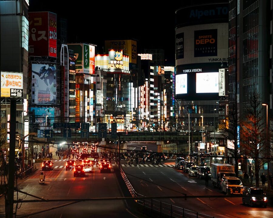 Shinjuku Tokyo street at night with neon lights and traffic