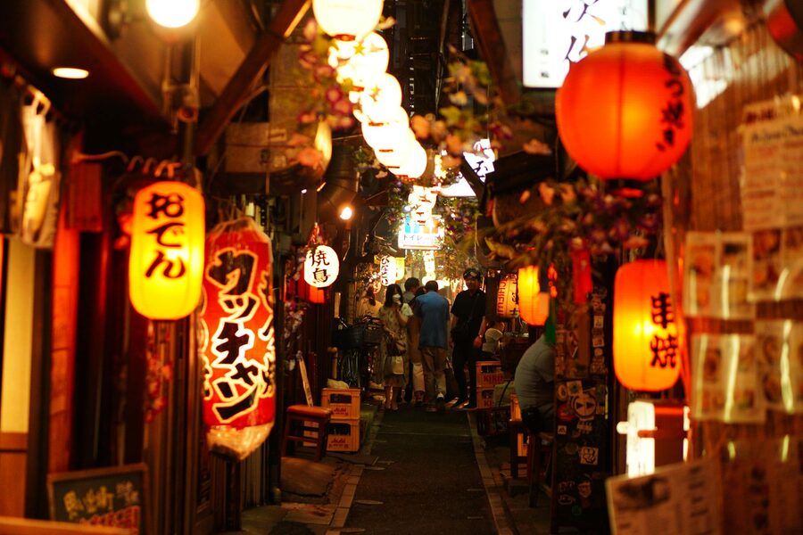 Narrow alley in Shinjuku Tokyo lit up with colorful signs at night