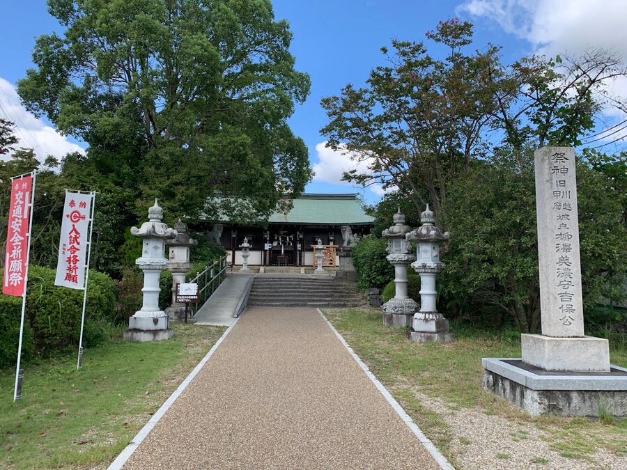 Peaceful entrance to traditional Japanese shrine surrounded by lush greenery