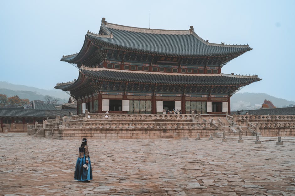 Woman in traditional hanbok walking past Gyeongbokgung Palace