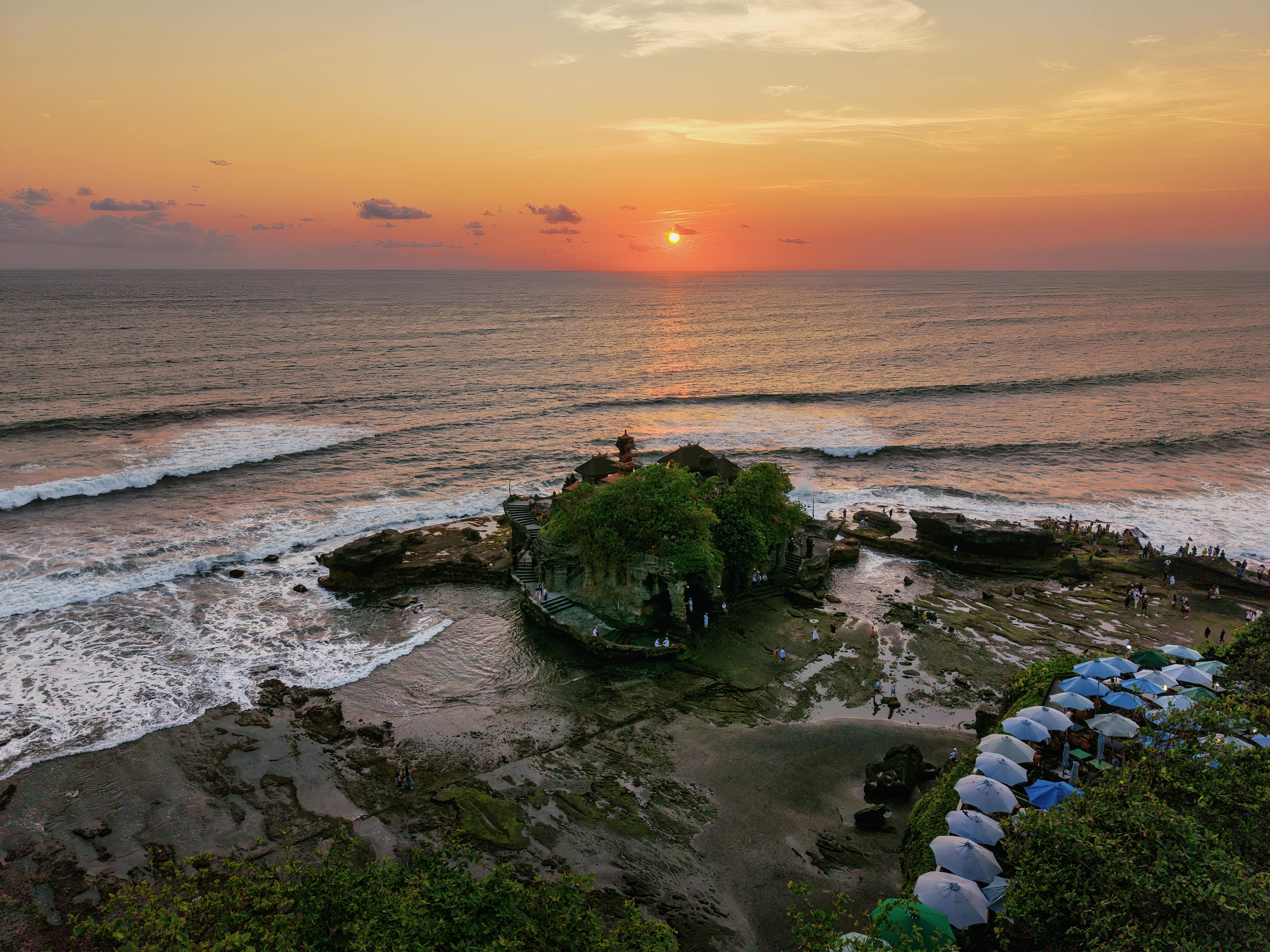 Golden sunset over Tanah Lot Temple with ocean surf