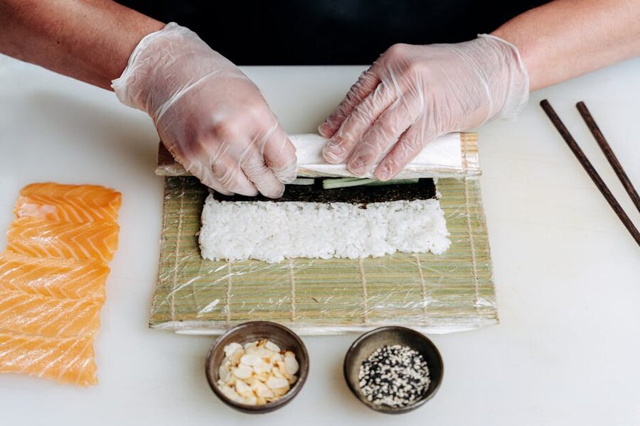 Sushi preparation with fresh salmon on bamboo mat