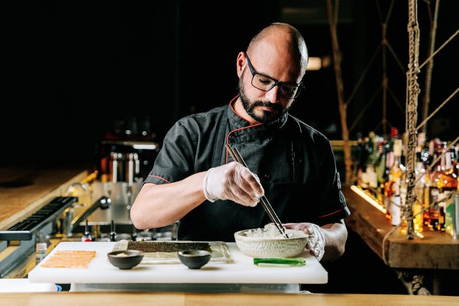 Chef crafting sushi with precision in kitchen