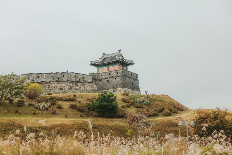 Hwaseong Fortress wall in autumn with orange and red foliage