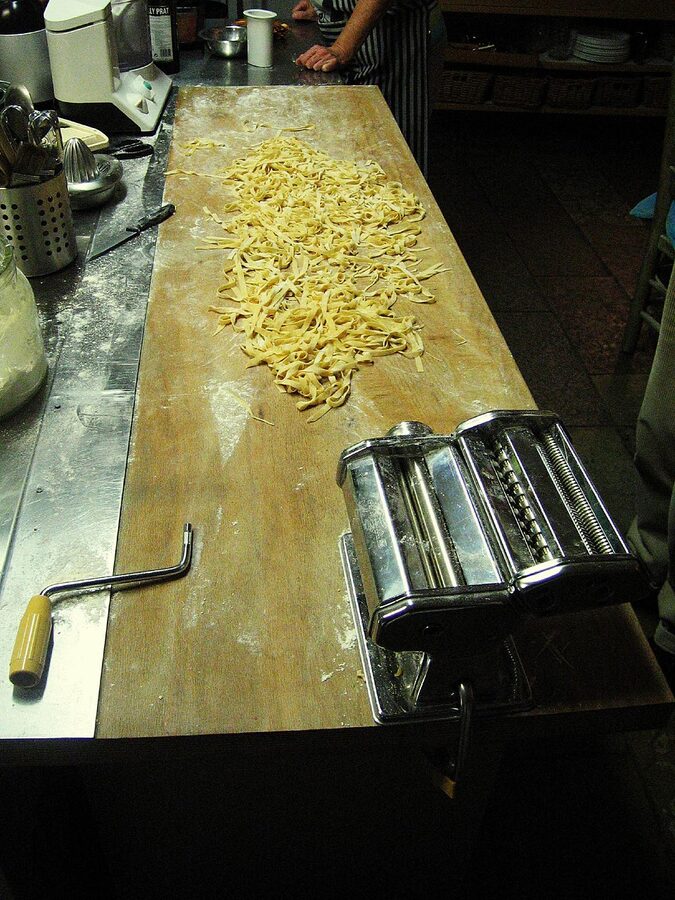 Tagliatelle being shaped by hand at a pasta cooking class