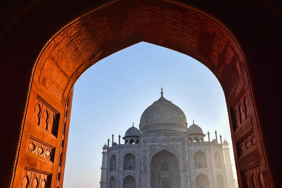Taj Mahal framed by an ornate archway at sunrise