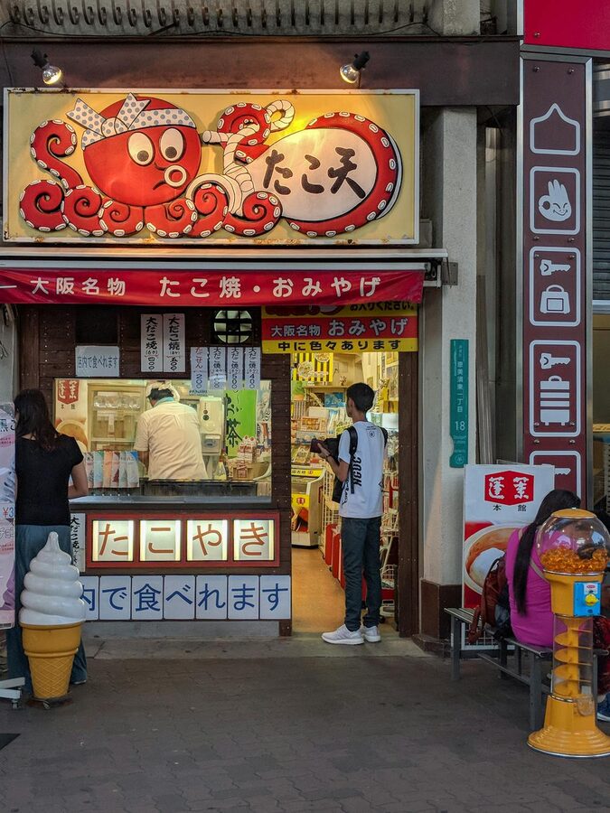 Colorful takoyaki shop with bright signage in Osaka Japan