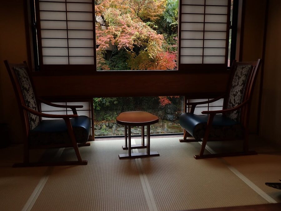 Cozy Japanese room with tatami mats chairs and garden view through shoji windows