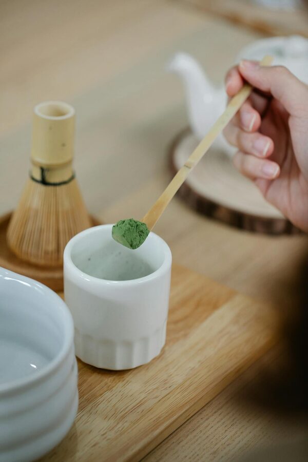 Tea ceremony host wearing kimono preparing matcha