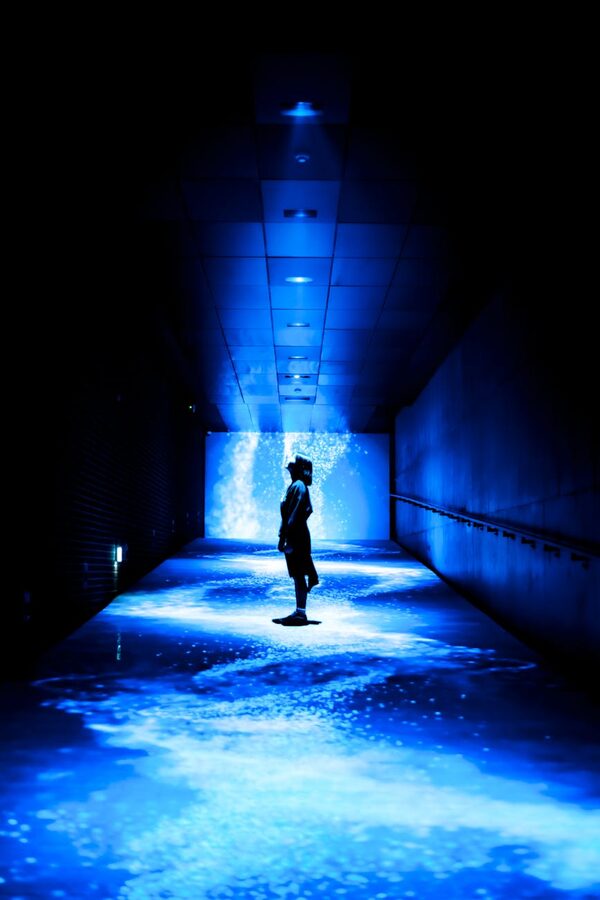 Silhouette in a futuristic blue-lit corridor