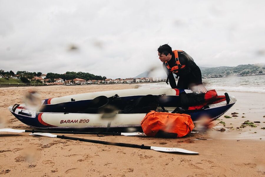 Pushing a kayak from a sandy shore in a wetsuit