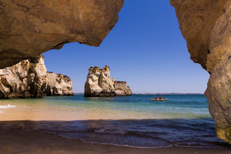 Kayak paddling near a sea cave in clear water