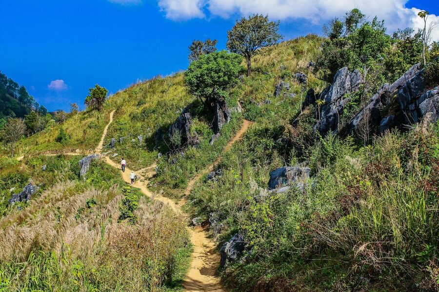 Lush green mountain landscape with bright blue sky in Thailand