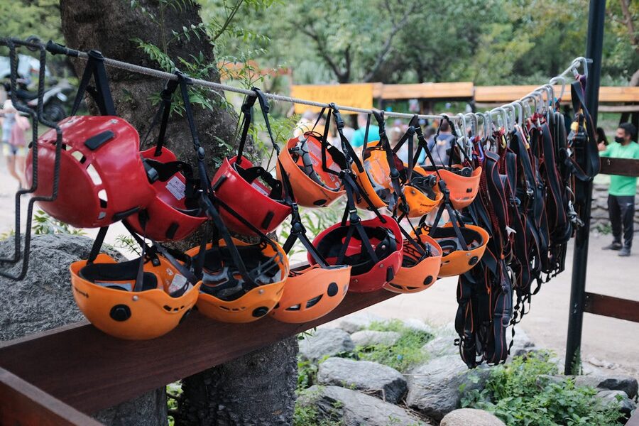 Row of colorful climbing helmets hanging at an outdoor adventure park