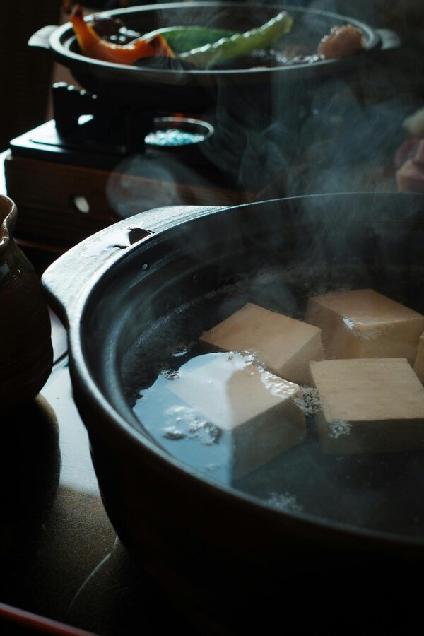 Steaming Japanese tofu pot with vegetables and broth
